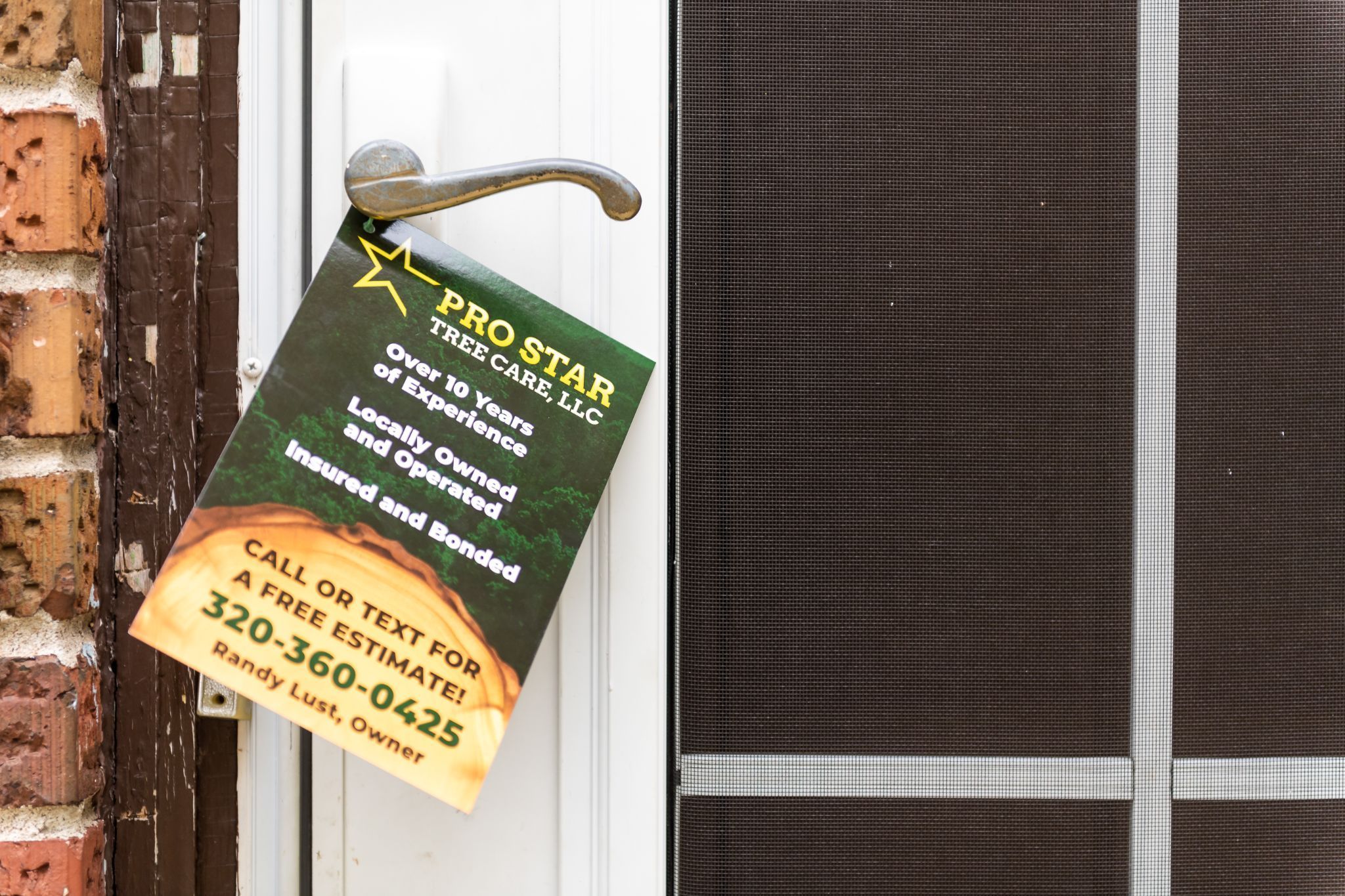 Pro Star Tree Care flyer hanging on front door handle