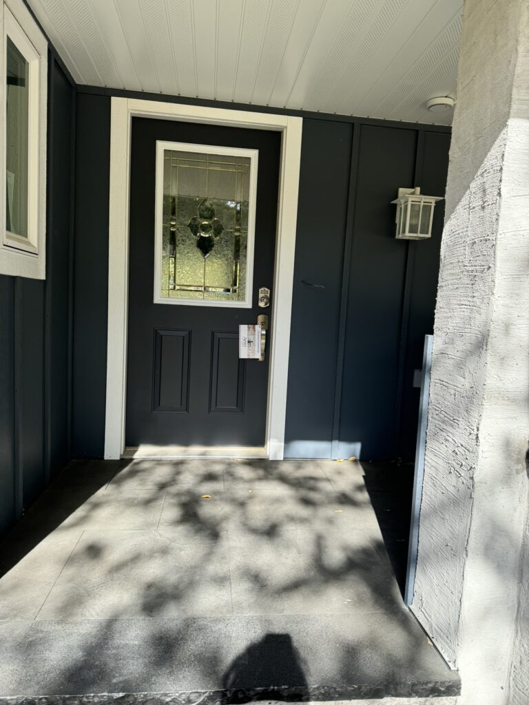 Black front door with glass panel and white trim